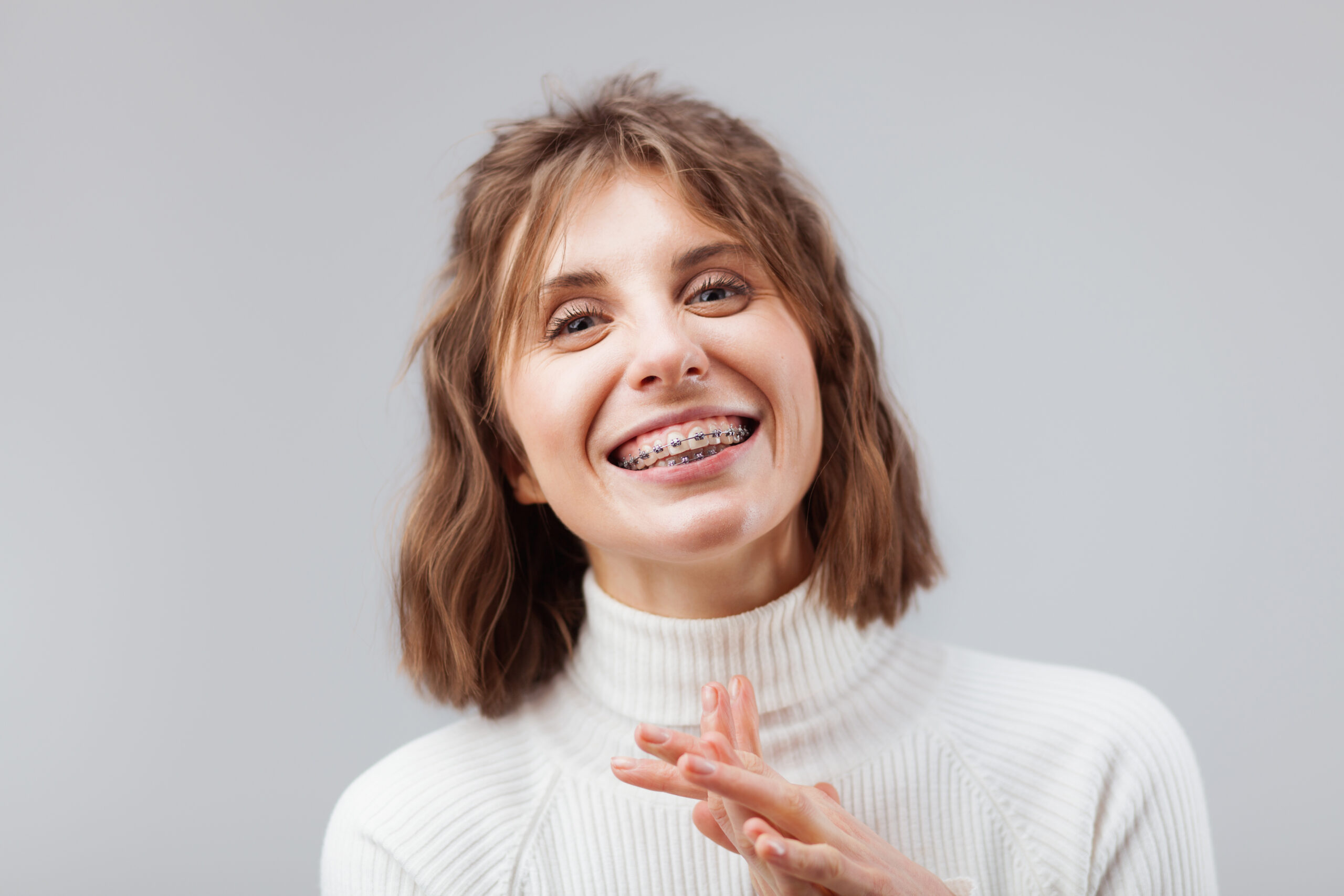 Young beautiful happy woman with dental braces on her teeth
